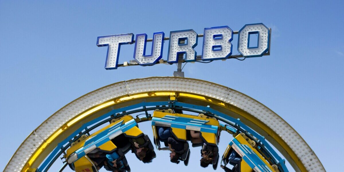 person riding on yellow and blue Turbo roller coaster