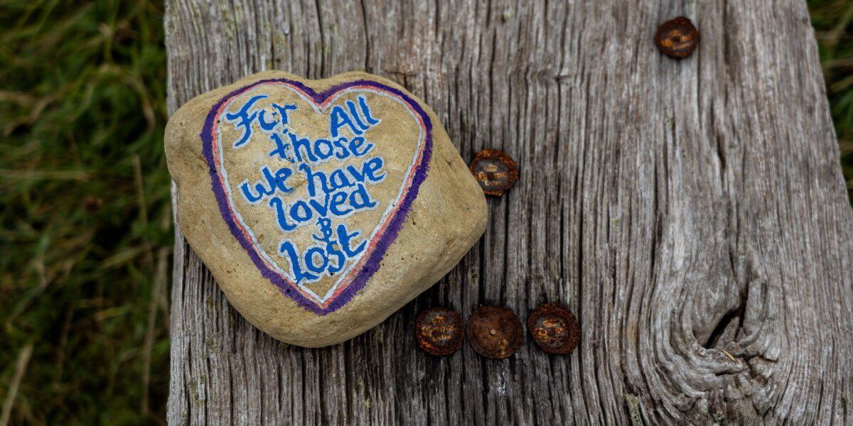 Photo of a rock painted with a message of grief