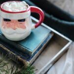 white and red ceramic mug on books