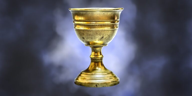 Old chalice on blue clouds background