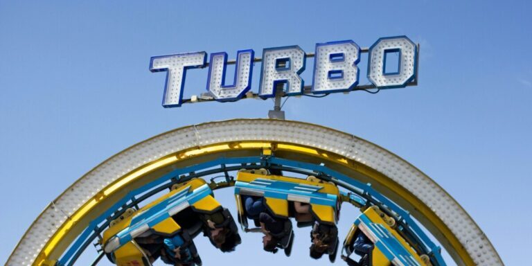person riding on yellow and blue Turbo roller coaster