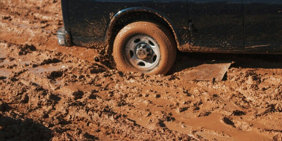 black car stuck on mud